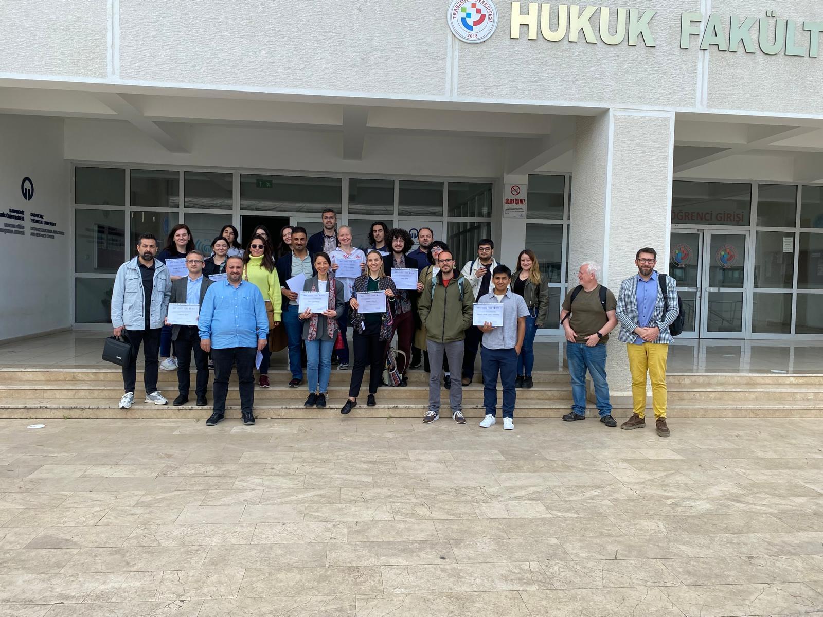 Group photo of the training school attendees at the entrance to the university building